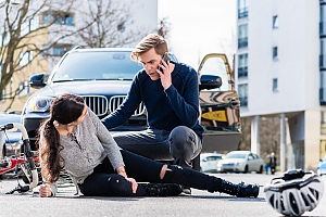 male driver comforts injured woman bicyclist