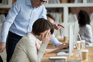 female employee suffering from discrimination of angry male boss