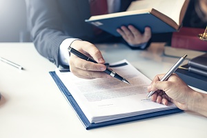 lawyer and client signing paperwork