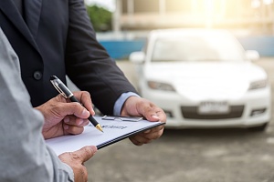 man filing a claim and signing a sheet of paper