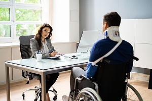 woman car accident lawyer meets with client in wheelchair