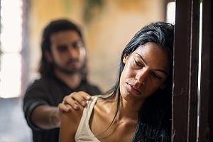 man puts hand on abused woman shoulder