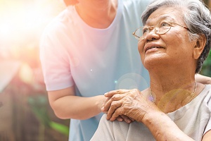 women holding hands of caregiver in light of elder abuse