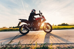 fast motorcycle drive on asphalt road at sunset