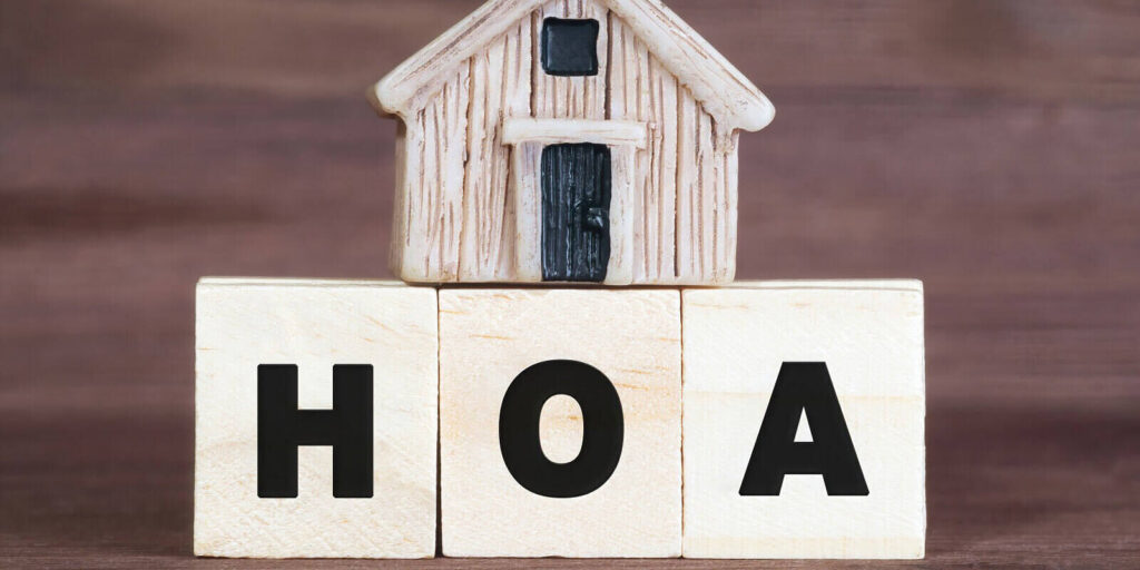 miniature house on top of wooden blocks reading hoa