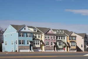 row of brightly colored townhouses with birght blue sky
